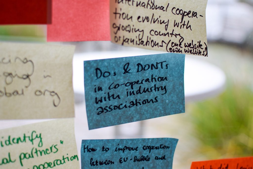 Photograph of post-its with different agenda topics on a glass wall.