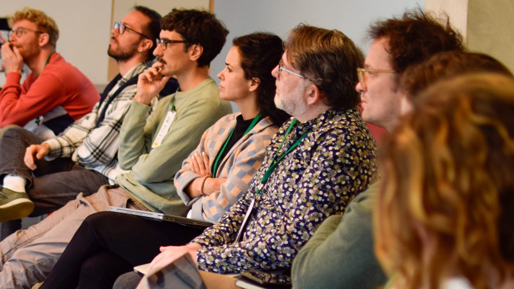 Photograph showing different people listening attentively to a presentation.